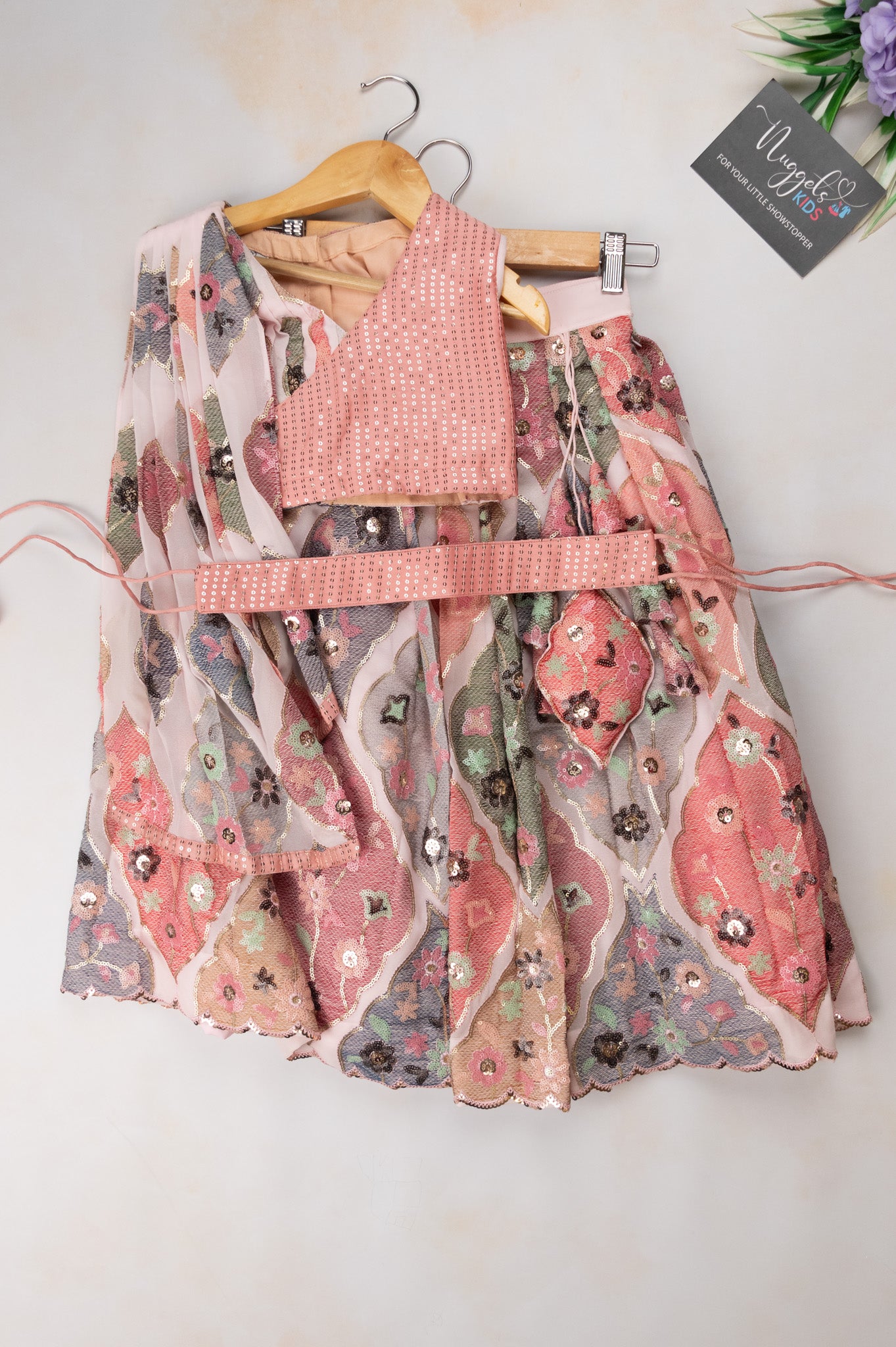 Pre Order: Baby pink embroidered lehenga, pleated flap designed choli and Tie up belt