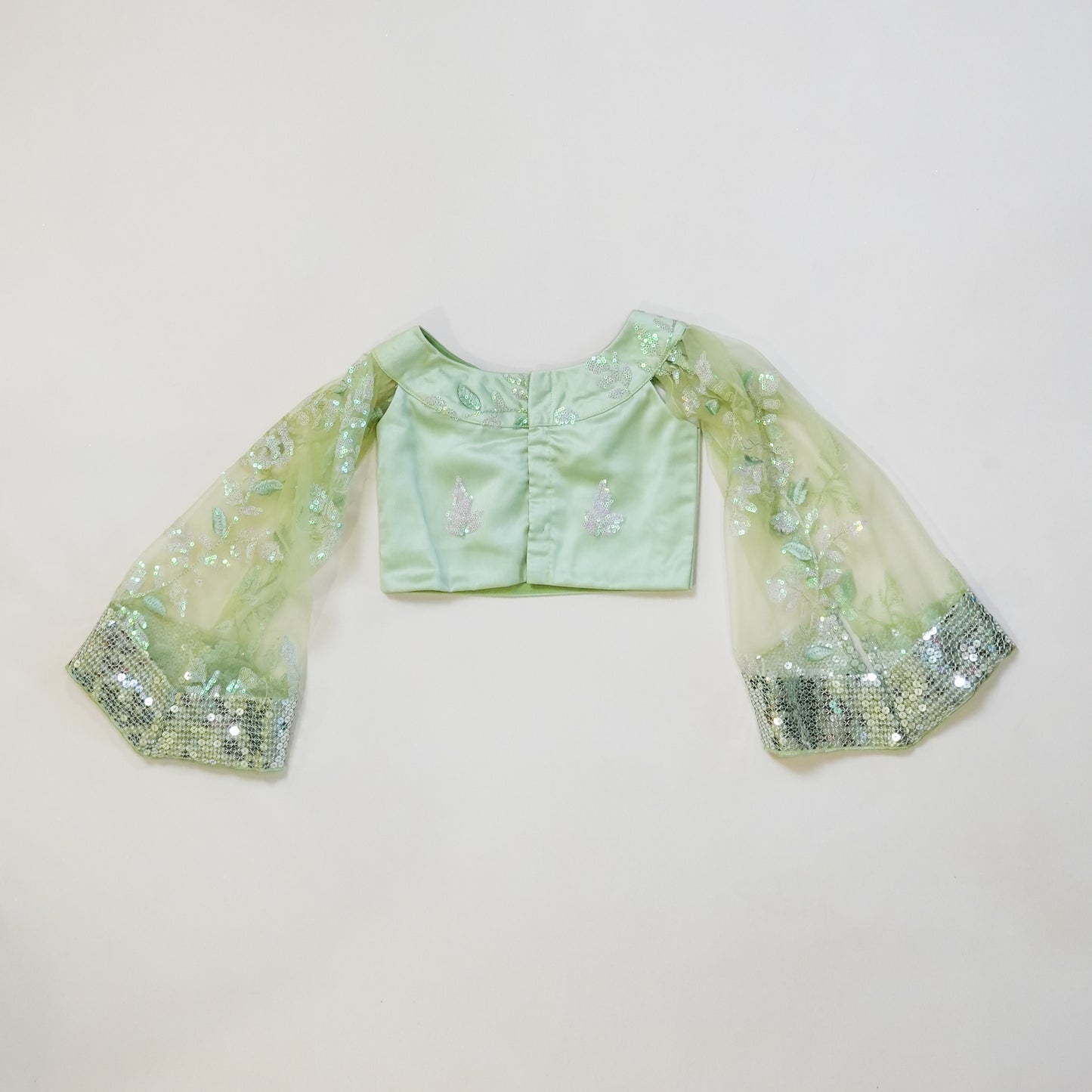 Pre Order: Pastel green sequined lehenga with halter neck top and cape style sleeves